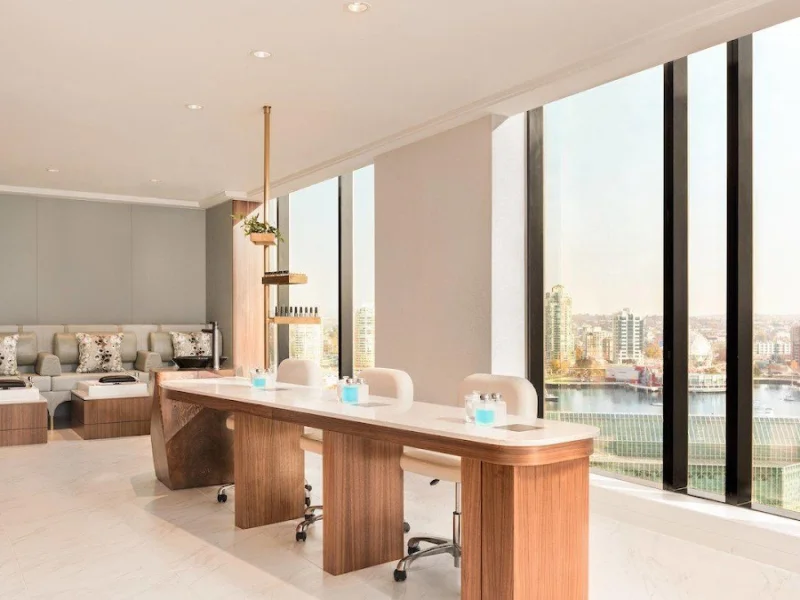 Bright spa manicure stations beside expansive windows and skyline views