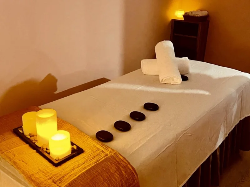 Quiet treatment room with massage table, candles, and warm spa ambiance