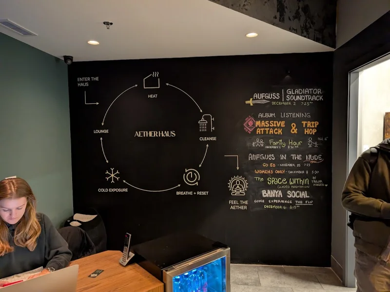 AetherHaus reception wall with wellness ritual signage and event board
