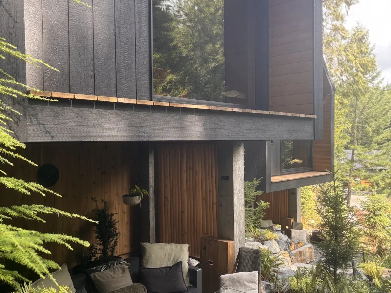 Covered outdoor lounge with fire feature and modern forest lodge architecture