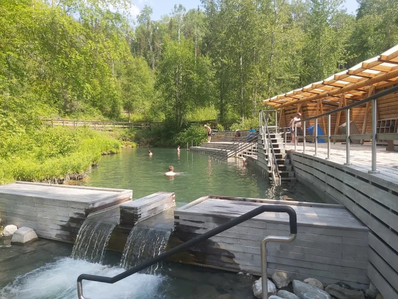 Forest hot spring pools with wooden decks in a secluded riverside setting