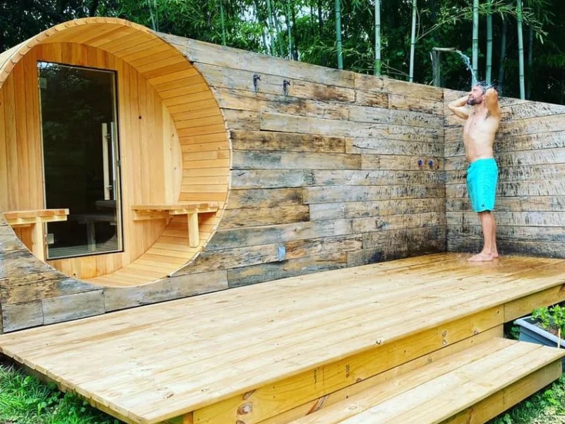 Outdoor barrel sauna with rustic wood deck and bamboo garden setting
