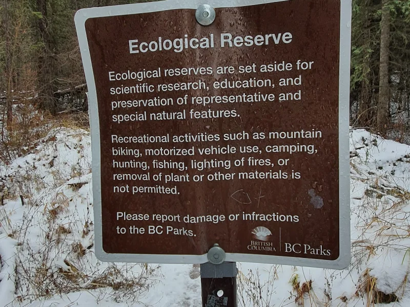 Snowy trail with warning signs at an ecological reserve hot spring area