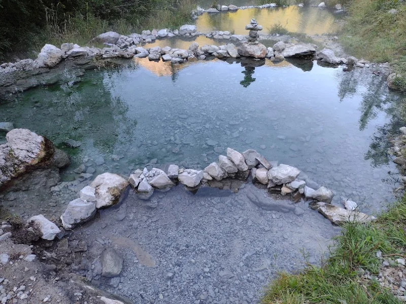 Stone-lined hot spring pools with clear water and soft evening light