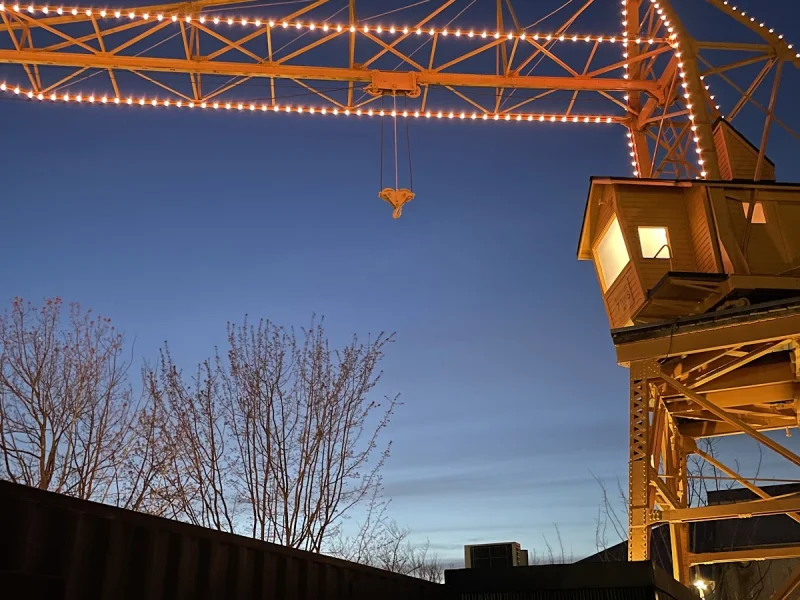 Granville Island crane lit at dusk above the wellness venue skyline