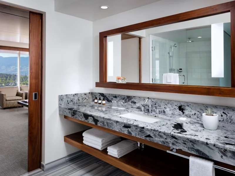 Luxury marble vanity with mountain and ocean views through spa bathroom window