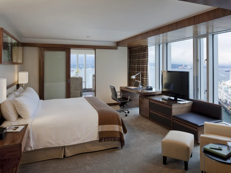 Modern luxury guest bedroom suite with king bed and panoramic mountain and water views