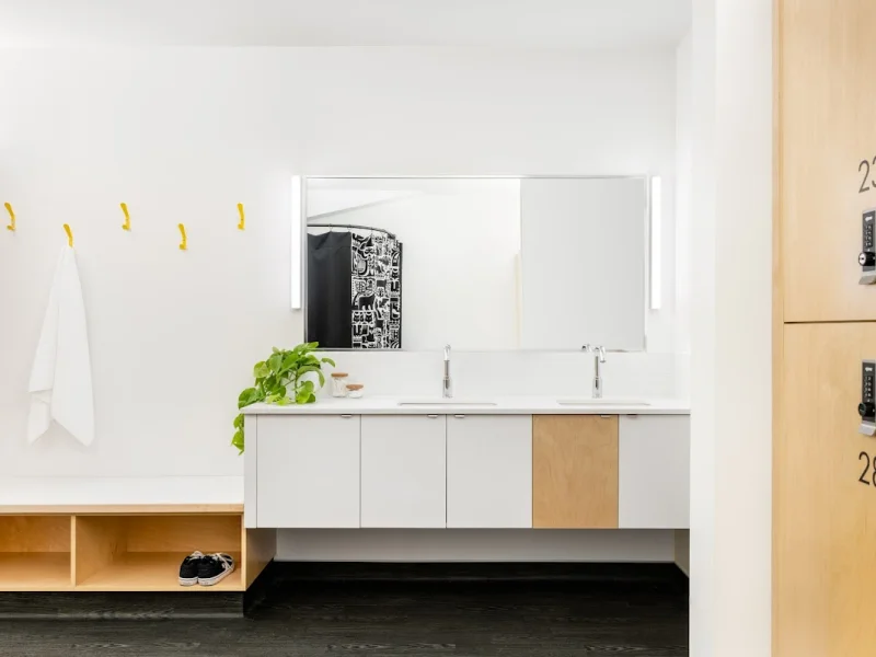 Clean spa locker room with double vanity and natural wood storage