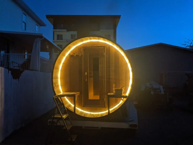 Dramatic nighttime sauna trailer with glowing circular entrance lighting