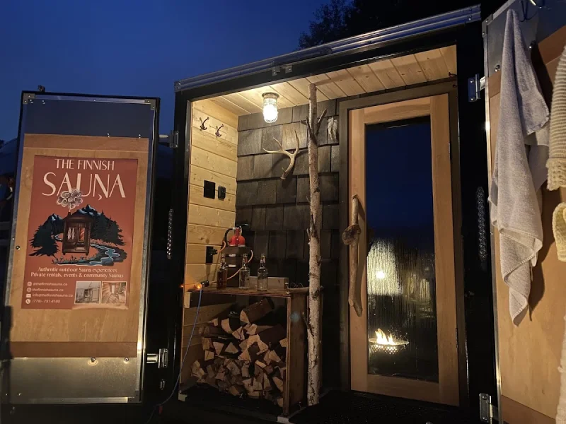 Cozy outdoor Finnish sauna trailer glowing at night with rustic wood details