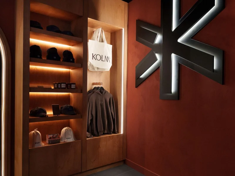 Retail corner with branded merchandise and illuminated display shelving