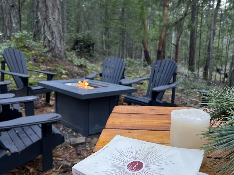 Forest fire pit lounge with candlelit seating at a luxury outdoor spa