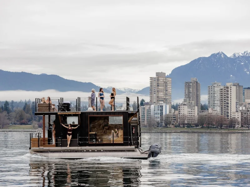Floating sauna boat with guests, Vancouver skyline, and mountain views