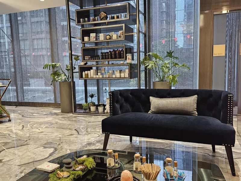 Elegant spa lounge with plush seating, curated products, and floor-to-ceiling city windows